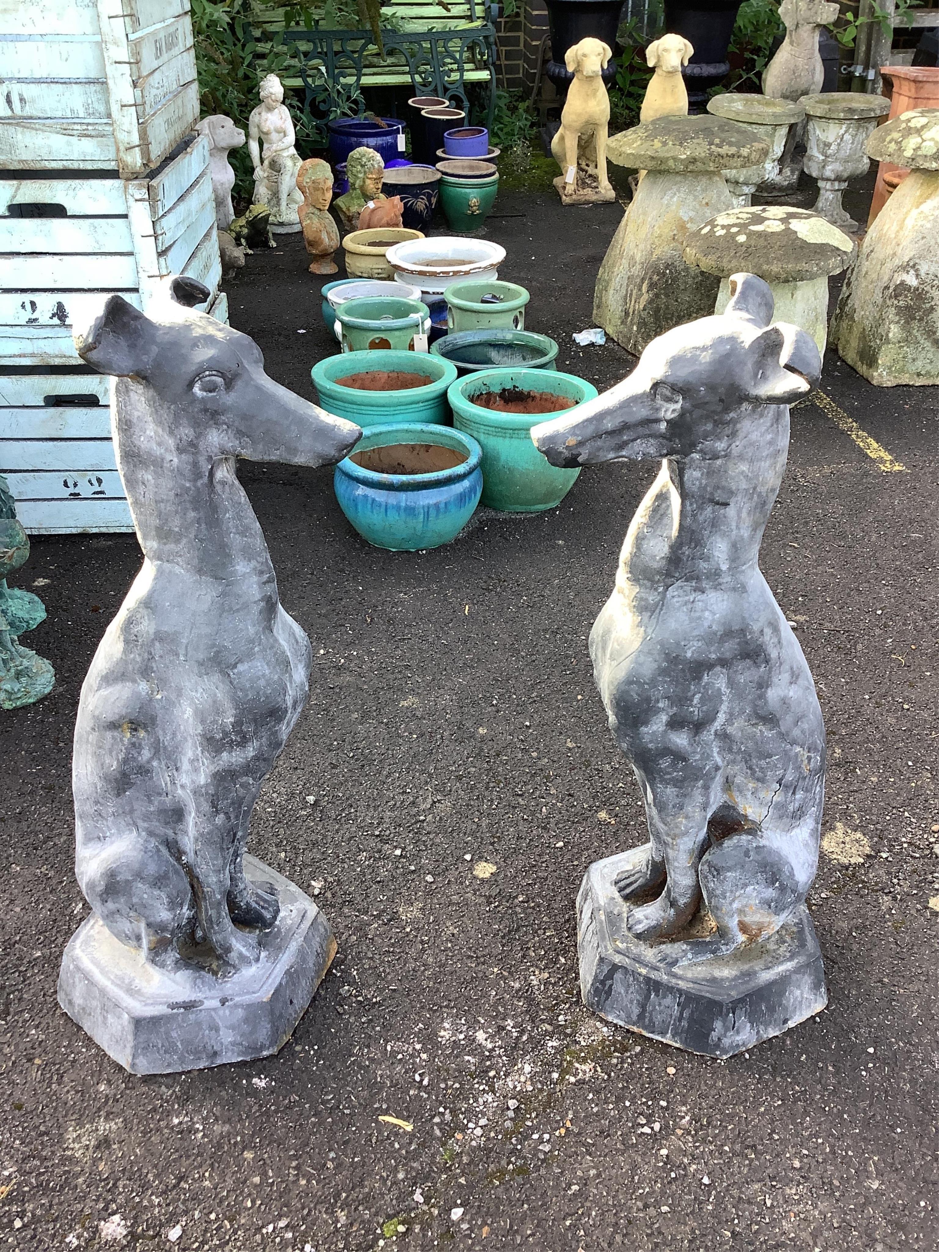 A pair of black painted cast iron models of seated hounds, height 91cm. Condition - weathered